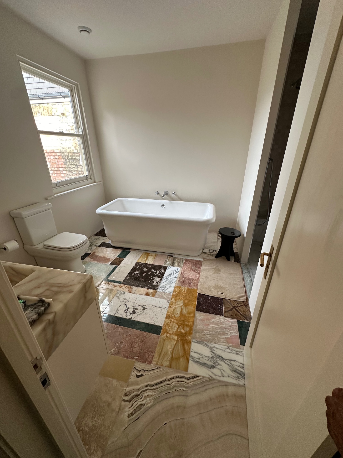 Full bathroom view with mixed marble flooring